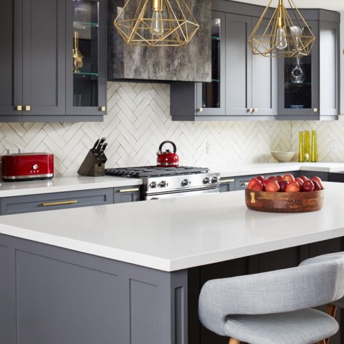 toronto life - toronto home renovation - small space open concept living - dark grey kitchen cabinetry white quartz counters - gold lighting and scandi barstools - white chevron tile backsplash - linda mazur design toronto designer