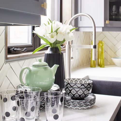 annex toronto kitchen renovation dark gray cabinets white counters black windows - white chevron tile backsplash and pretty black and white dishes - blanco modern faucet with anthracite silgranit ikon sink - linda mazur design toronto designer full serivce design build