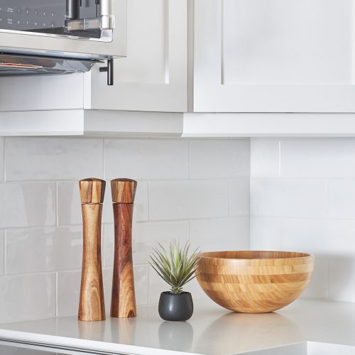 two tone toronto condo kitchen - york region condo renovation - warm wood accessories for your kitchen - white quartz counter tops - black kitchen hardware - microwave over range - linda mazur design