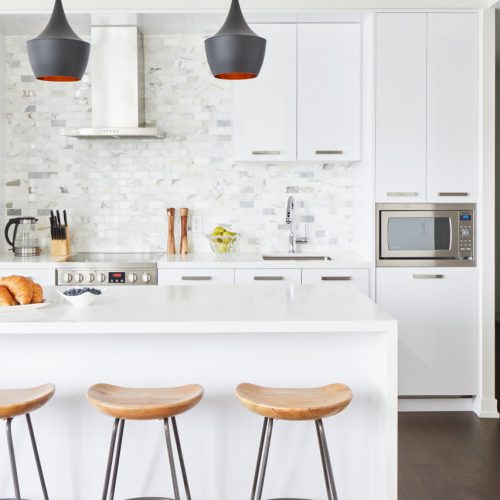 corktown condo - all white kitchen with wood barstools and black pendants - marble full wall backsplash and wood floors - linda mazur design toronto designer canadian designer full service design - small space design