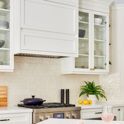 markham luxury family kitchen renovation - cream white custom millwork cabinets and range hood with glass cabinets - white quartz waterfall countertops black porcelain flooring - linda mazur design canadian designer