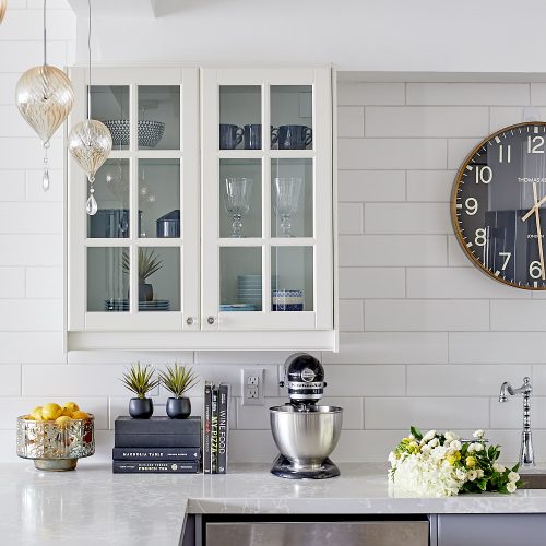 toronto condo kitchen renovation - white glass custom cabinetry with quartz countertop - white subway tile backsplash and pretty glass pendants - linda mazur design