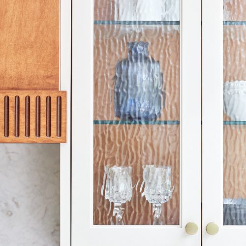mississauga custom kitchen renovation - wood custom range hood with fluted detail - transitional - glass cabinet door fronts - quartz counter and backsplash - linda mazur design toronto designer