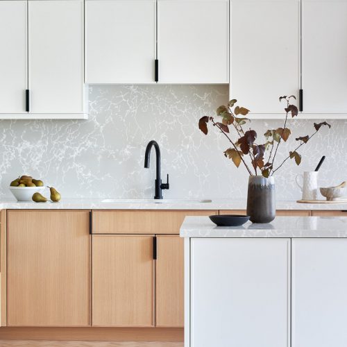 toronto condo kitchen renovation scandi, black barstool vignette, quartz counter tops, natural wood cabinets, two colour cabinets, white cabinets, custom kitchen, herringbone floors, toronto designer, built-in fridge, panelled fridge and pantry linda mazur design