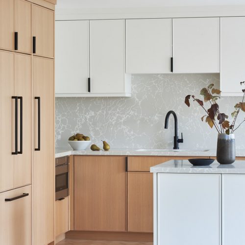 toronto condo kitchen renovation scandi, black barstool vignette, quartz counter tops, natural wood cabinets, two colour cabinets, white cabinets, custom kitchen, herringbone floors, toronto designer, built-in fridge, panelled fridge and pantry linda mazur design